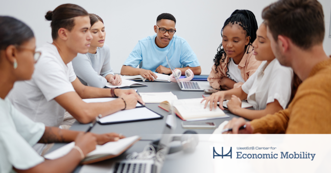 Adults collaborating and discussing around a table with a Center for Economic Mobility logo on the bottom right corner